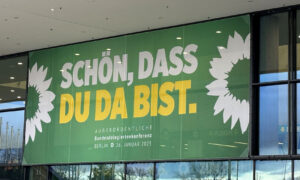 Großes Banner vor dem Eingang der Konferenz mit der Aufschrift „Schön, dass du da bist.“ in grüner, gelber und weißer Schrift. Es kündigt die außerordentliche Bundesdelegiertenkonferenz der Grünen in Berlin an.