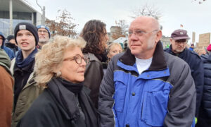 Beate Müller-Gemmeke im Gespräch mit einem Mann in blauer Jacke auf der Demo. Beide schauen sich aufmerksam an.