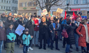 Eine große Menschenmenge versammelt sich auf einem Marktplatz in einer Altstadt. Viele halten Schilder und Transparente gegen Rechts. Beate Müller-Gemmeke steht mittig in der Menge, neben ihr sind auch junge Menschen mit Plakaten zu sehen. Die Sonne scheint, der Himmel ist blau.