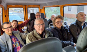 Beate Müller-Gemmeke und weitere Mitglieder der Delegation sitzen in einem Minibus und lächeln in die Kamera. Die Stimmung wirkt herzlich.